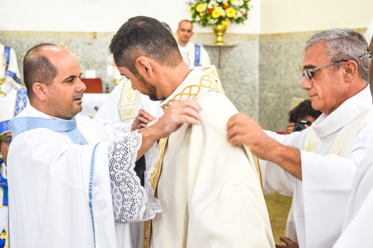 Padre João Paulo atual pároco de Japeri e Padre Paulo Machado, padre que enviou o neo-sacerdote para o seminário revestem Adriano com as vestem sacerdotais.